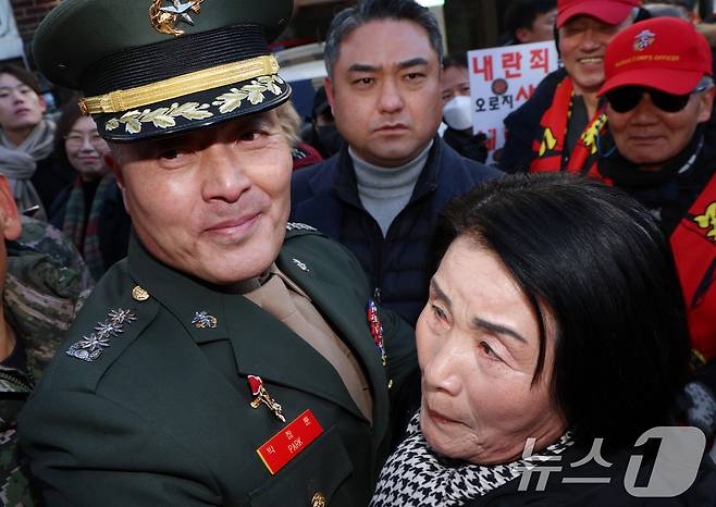 채 상병 순직 사건과 관련해 항명 및 상관명예훼손 혐의로 기소된 박정훈 전 해병대 수사단장(대령)이 지난 1월 9일 오전 서울 용산구 중앙지역군사법원에서 열린 1심 선고공판을 마치고 나와 어머니와 포옹을하고 있다.  2025.1.9/뉴스1 ⓒ News1 김명섭 기자