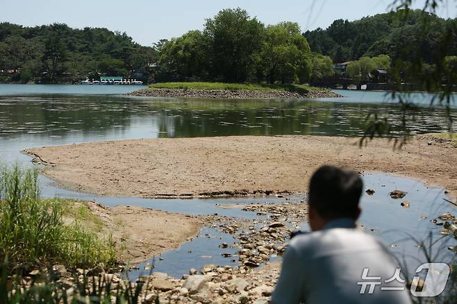 마른 장마와 폭염 등으로 바닥을 드러낸 제천 의림지에서 한 시민이 순주섬을 바라보고 있다.2025.7.10/뉴스1ⓒ News1 손도언 기자