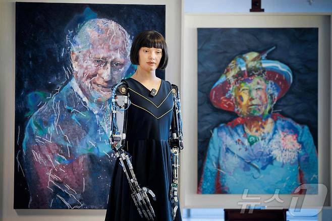 9일(현지시간) 스위스 제네바에서 국제전기통신연합(ITU) 주최로 열린 'AI 포 굿(AI for Good) 글로벌 정상회의' 행사장에서 인간형 예술가 로봇 아이-다(Ai-Da)가 자신이 그린 찰스 3세 영국 국왕과 엘리자베스 2세 여왕의 초상화 앞에 서 있다. 2025.07.09. ⓒ AFP=뉴스1 ⓒ News1 윤다정 기자
