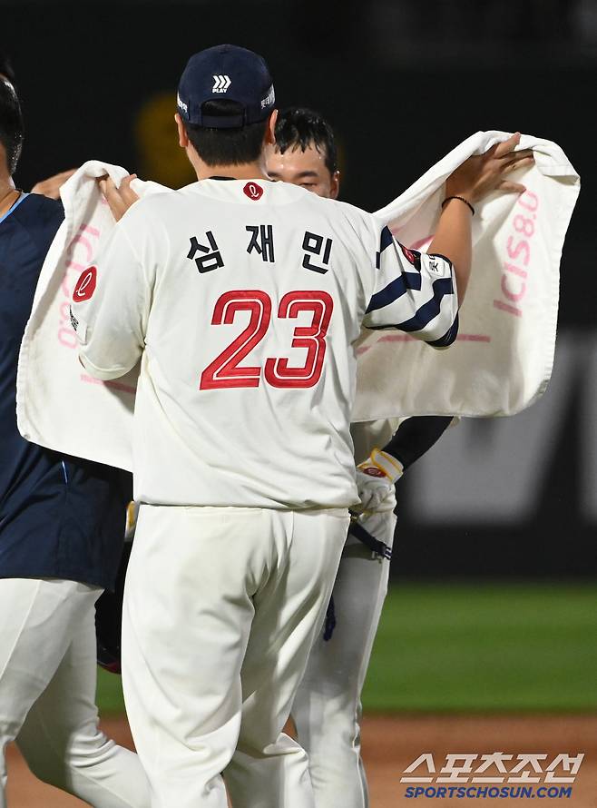 커다란 수건을 펼쳐든 다정한 선배 심재민