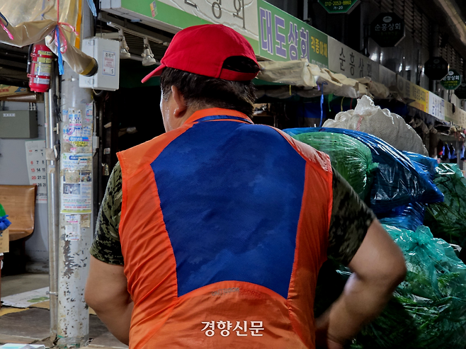 지난 8일 서울 동대문구 경동시장 광성상가에서 한 노동자가 땀에 젖은 채 물건을 옮기고 있다. 우혜림 기자