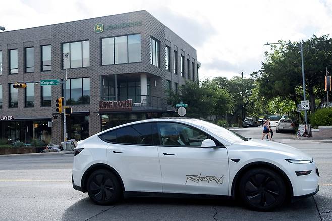 A Tesla robotaxi drives on the street along South Congress Avenue in Austin, Texas, on June 22. [REUTERS/YONHAP]