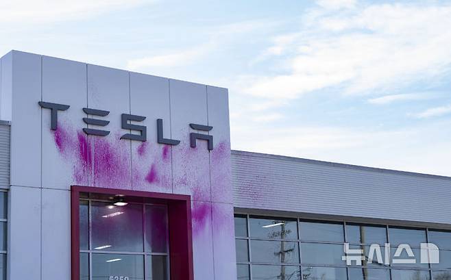 [몬트리올=AP/뉴시스] 지난 3월 19일(현지 시간) 캐나다 몬트리올에 있는 테슬라 대리점이 분홍색 페인트로 훼손돼 있다. 2025.03.20.