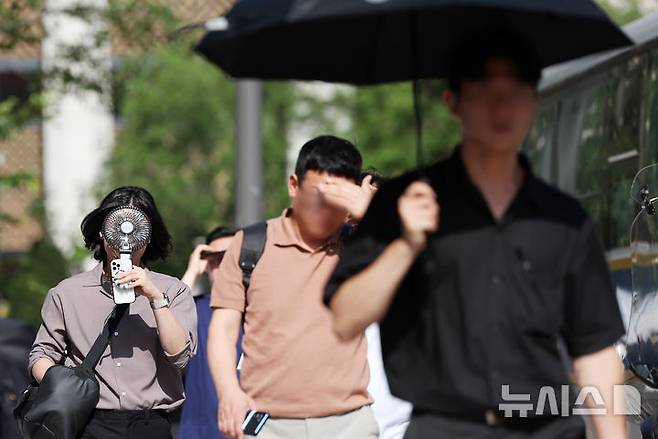 [서울=뉴시스] 조성우 기자 = 폭염이 계속되는 10일 서울 종로구 거리에서 시민이 선풍기와 양산 등으로 더위를 식히며 이동하고 있다. 2025.07.10. xconfind@newsis.com