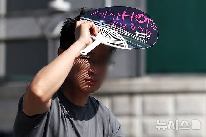 [서울=뉴시스] 조성우 기자 = 폭염이 계속되는 10일 서울 종로구 거리에서 한 시민이 부채로 햇볕을 피하며 이동하고 있다. 2025.07.10. xconfind@newsis.com