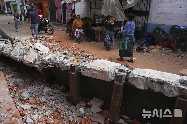 [산타 마리아 데 헤수스=AP/뉴시스] 과테말라에서 규모 5.7의 지진이 발생한 가운데 9일(현지 시간) 산타 마리아 데 헤수스 주민들이 파손된 주택 잔해 옆을 지나가고 있다. 현지 당국은 지난 8일 오후부터 규모 3.0에서 5.7의 본진과 여진이 150차례 이상 이어지며 최소 4명이 숨졌다고 밝혔다. 2025.07.10.