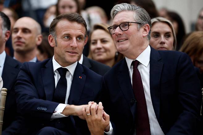 7월 9일(현지시간) 영국 런던의 대영박물관을 방문한 에마뉘엘 마크롱 프랑스 대통령(왼쪽)과 키어 스타머 영국 총리가 서로 손을 맞잡고 있다. 연합뉴스