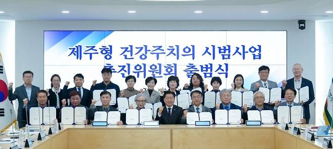 오영훈(앞줄 왼쪽 다섯 번째) 제주지사가 지난해 10월 28일 도청 한라홀에서 ‘제주형 건강주치의 사업 추진위원회’ 출범식을 가진 뒤 공동위원장인 고병수(여섯 번째) 탑동365일의원 원장 등 추진위원들과 기념촬영을 하고 있다.   제주도 제공