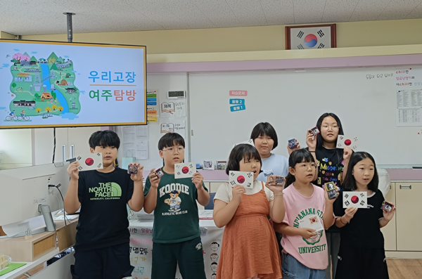 ‘우리 고장 탐방’ 프로그램에 참여한 이포초등학교 학생들이 직접 제작한 태극기와 독립운동가 큐브를 들고 기념촬영을 하고 있다. 2025.7.2 /이포초 제공