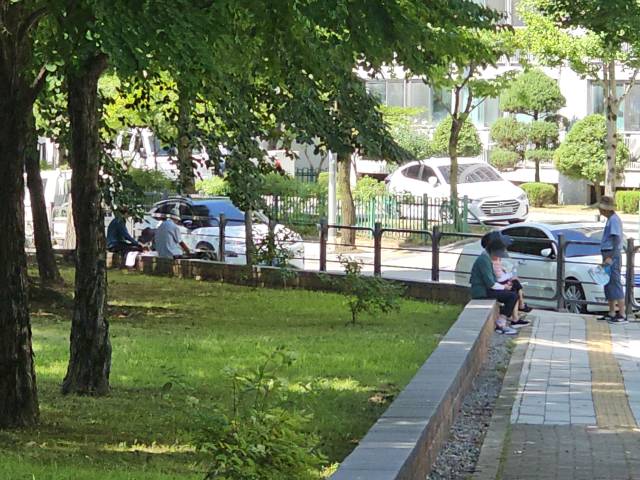 충주 대가미공원에 기존 나무 담장을 철거하고 설치한 하이랜드 스톤블럭에 주민들이 앉아 잠시 휴식을 취하며 폭염 속 더위를 식히고 있는 모습이다.사진=김의상 기자