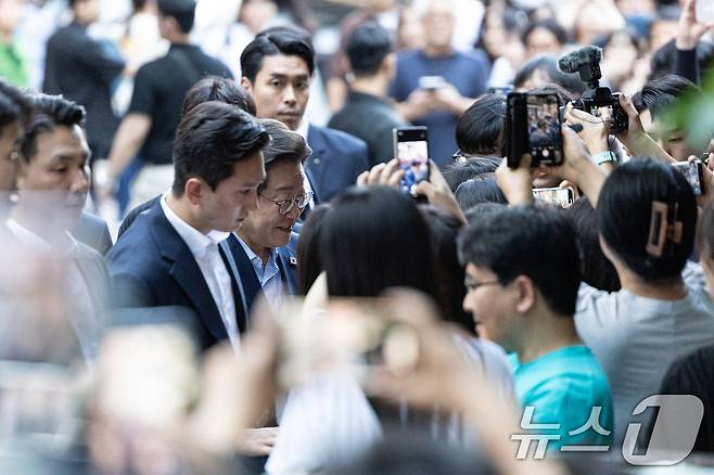 이재명 대통령이 11일 시민들과 저녁 식사를 위해 서울 종로구 광화문 인근의 한 식당으로 이동하며 시민들과 인사 나누고 있다. 2025.7.11/뉴스1 ⓒ News1 이승배 기자