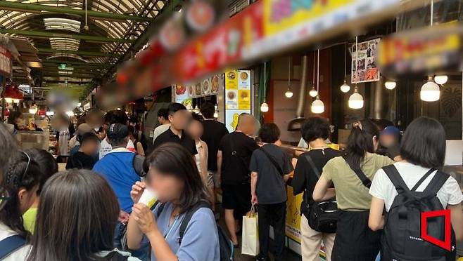 광장시장 먹자골목 초입 꽈배기 가게 앞에서 줄 서 있는 방문객들. 이은서 기자.