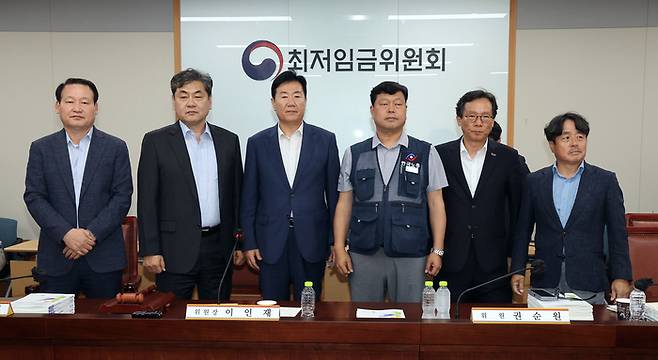 10일 정부세종청사에서 열린 제12차 전원회의에서 내년 최저임금을 시간당 1만320원으로 17년만에 합의로 결정한 공익위원-사용자위원-근로자위원들이 기념 촬영을 하고 있다. 왼쪽부터 하헌제 상임위원, 이인재 위원장, 사용자위원인 류기정 한국경영자총협회 전무, 근로자위원인 류기섭 한국노총 사무총장, 사용자위원인 이명로 중소기업중앙회 인력정책본부장, 공익위원인 권순원 숙명여대 교수. 연합뉴스.