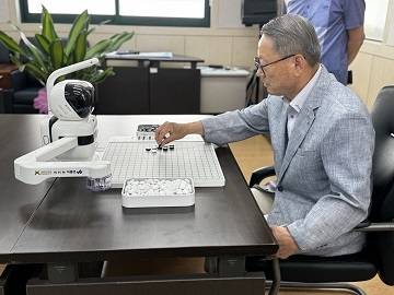 NHN이 진천군에 기증한 AI 돌봄로봇 ‘바둑이’를 한 어르신이 사용하고 있는 모습.