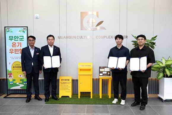 전남 무안군 관계자들과 사단법인 온기 관계자들이 온기우편함 옆에 서서 기념촬영을 하고 있다. [사진=무안군]