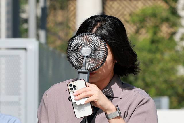 ▲ 전국 대부분 지역에 폭염 특보가 발효된 10일 서울 종로구에서 휴대용 선풍기를 든 시민이 이동하고 있다. 연합뉴스