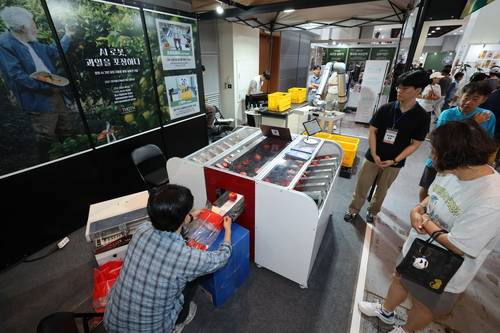 11일 오전 서귀포시 중문동 제주국제컨벤션센터에 열린 제7회 농촌융복합산업제주국제박람회 ‘푸파페 제주’에서 주식회사 토트(THOTH) 관계자들이 자사의 로봇 AI 기반 과일 포장 자동화 솔루션을 선보이고 있다. 연합뉴스