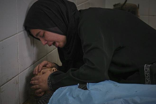 En attendant un supplément nutritionnel devant le centre médical dans le district de Gaza, dans le district de Gaza, le dixième (heure locale), la famille est couronnée devant le corps d'une fille de 13 ans, l'une des 10 personnes décédées dans le raid aérien d'Israël. AP Yonhap News
