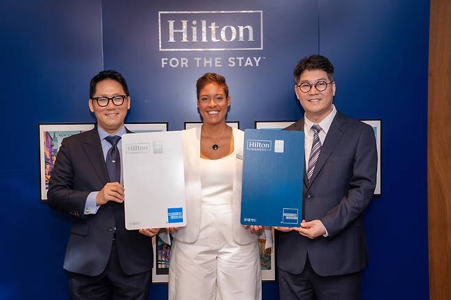 Vice President of Marketing & Loyalty in the Asia Pacific Gretchen Moore, center, Im Jeong-bin, head of the Card Sales Division at Lotte Card, right, and Kim Sean You, American Express Country Manager pose for a photo during a media day held at Conrad Seoul in Yeouido District, western Seoul on June 18. [HILTON]