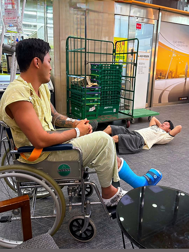 제4대 로드FC 라이트급 챔피언 박시원이 2025년 6월 로드FC 73 웰터급 TKO패 과정에서 다친 발목에 깁스를 한 채 휠체어를 타고 있다. 오른쪽은 서울특별시 강북삼성병원으로 문병을 온 제3대 로드FC 플라이급 챔피언 이정현. 사진@parksirong