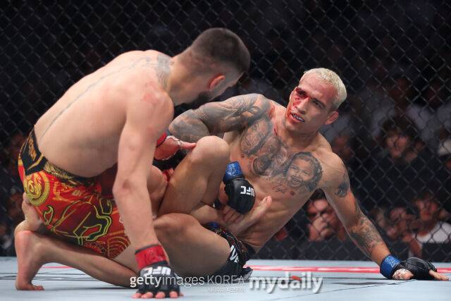 올리베이라(오른쪽)가 토푸리아를 상대로 서브미션 기술을 시도하고 있다. /게티이미지코리아