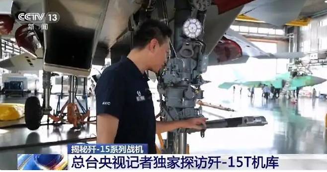 [서울=뉴시스]중국이 자국산 5세대 전투기 J-35와 캐터펄트(사출기) 전용 함재기 J-15T의 생산시설을 공개했다. 중국 차세대 항공모함 전력 강화의 일환으로, 일각에서는 무력 과시 성격으로 해석하고 있다. 중국 기자가 J-35 생산시설을 취재중인 모습. <사진출처: 중국중앙 TV 캡쳐> 2025.07.11