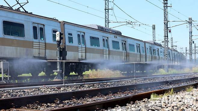 [서울=뉴시스] 전진환 기자 = 전국적인 폭염이 이어지고 있는 11일 서울 강서구 서울시메트로9호선 김포차량기지에서 운행을 마친 전동차가 들어오는 레일 주위로 '자동살수장치'가 가동되고 있다.  자동살수장치는 여름철 레일 온도가 일정 수준 이상으로 상승할 경우 자동으로 물을 분사해 온도를 낮추는 장치다. 2025.07.11. amin2@newsis.com