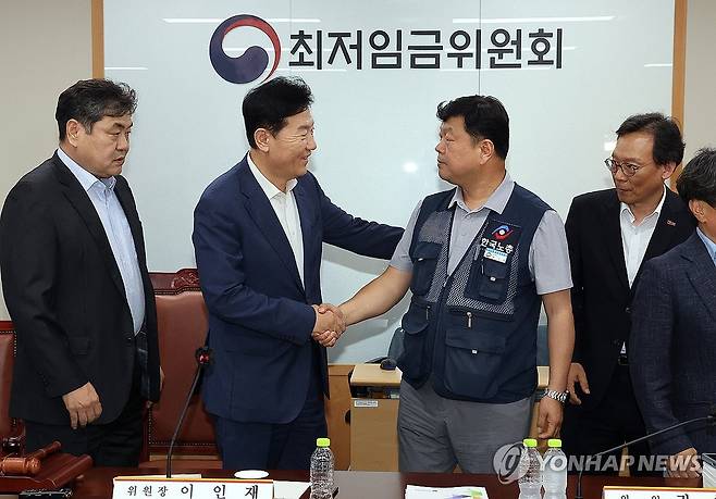 2026년 최저임금 시간당 1만320원…17년만에 합의로 결정 (세종=연합뉴스) 배재만 기자 = 최저임금위원회 사용자위원 운영위원인 류기정 한국경영자총협회 전무(왼쪽)와 근로자위원 운영위원인 류기섭 한국노총 사무총장이 10일 정부세종청사에서 열린 제12차 전원회의에서 내년 최저임금을 시간당 1만320원으로 17년 만에 합의로 결정한 뒤 악수하고 있다. 왼쪽은 이인재 위원장, 오른쪽은 이명로 중소기업중앙회 인력정책본부장. 2025.7.11 scoop@yna.co.kr