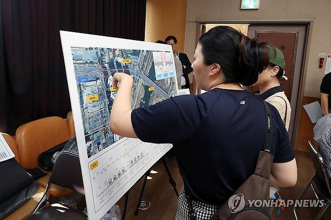광주 첨단대교 지상화 공청회 (광주=연합뉴스) 천정인 기자 = 11일 오후 광주 북구 첨단사회복지관에서서 열린 '첨단대교 지상화로 인한 교통체계 개선 및 교통혼잡 완화 방안' 공청회에서 주민들이 공사 개요가 담긴 지도를 살펴보고 있다. 2025.7.11 iny@yna.co.kr