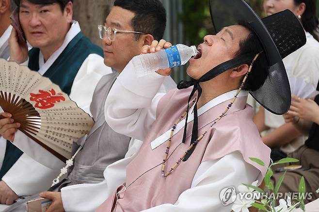 '찜통더위엔 선비도 덥기는 마찬가지' (대구=연합뉴스) 박세진 기자 = 2일 대구 중구 한옥 예식장에서 열린 다문화가정 전통혼례식에서 전통한복을 입은 류규하 대구 중구청장이 냉수를 마시고 있다. 2025.7.2 psjpsj@yna.co.kr