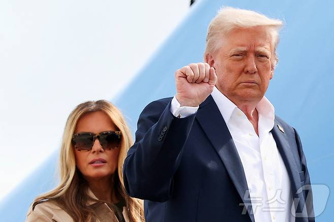 도널드 트럼프 미국 대통령이 11일(현지시간) 메릴랜드주 앤드루스 합동 기지에서 멜라니아 여사와 함께 에어포스원에 탑승하기 전에 주먹을 쥐어 보이고 있다. 트럼프 대통령은 이날 텍사스 홍수 피해 지역을 둘러볼 예정이다. 2025.07.11 ⓒ 로이터=뉴스1 ⓒ News1 류정민 특파원