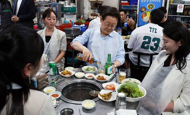이재명 대통령이 11일 저녁 서울 광화문 인근 한식당에서 시민들과 식사 중 술을 따르고 있다. 연합뉴스