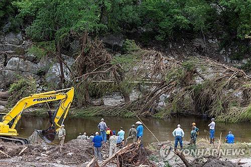 11일 미 텍사스 헌트의 홍수 피해 지역에서 잔해를 치우는 작업 [로이터=연합뉴스. 재판매 및 DB 금지]