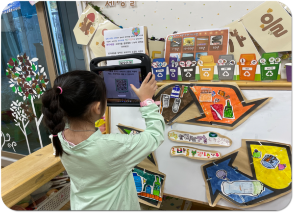 시립죽전어린이집에서 한 유아가 'E.S.G 놀이로 만나다!' 프로그램 활동 일환으로 QR코드를 스캔하고 있다.