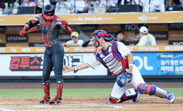 나눔 올스타의 박해민(LG 트윈스)이 12일 대전 한화생명볼파크에서 열린 2025 프로야구 올스타전 도중 스파이더맨 옷을 입고 등장하자 드림 올스타의 포수 강민호(삼성 라이온즈)가 다리 부분을 만져보고 있다. 연합뉴스