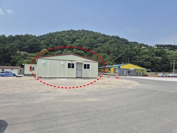 게이트볼장(오른쪽)에서 조망권이 방해된다며 지역 면장이 철거를 요구하는 현장사무실(왼쪽 점선 안).