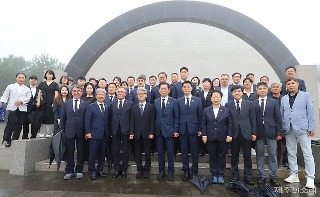 정청래 더불어민주당 당 대표 후보와 문대림 의원, 문정복 의원, 이성윤 의원, 김창범 유족회장, 김종민 이사장, 제주도의회 이상봉 의장, 김대진 의원, 송창권 의원, 임정은 의원, 하성용 의원, 강봉직, 김기환, 홍인숙 의원 등이 13일 4.3평화공원 위령제단 앞에서 사진을 찍고 있다. ⓒ제주의소리