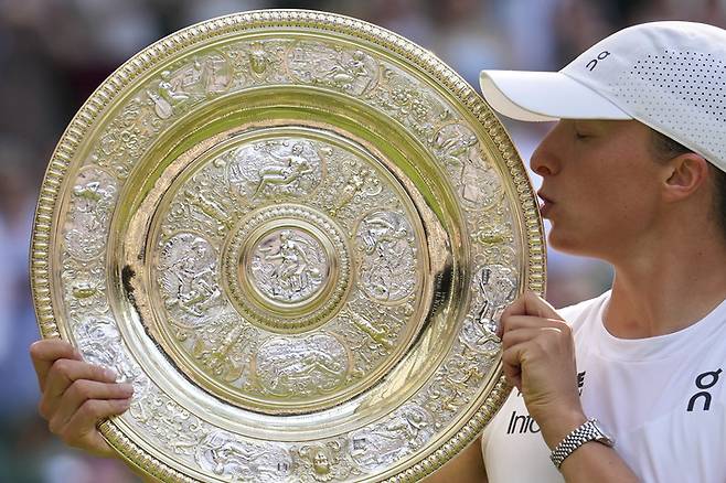 폴란드의 이가 시비옹테크가 2025년 7월 12일(토) 영국 런던에서 열린 윔블던 테니스 선수권 대회 여자 단식 결승전에서 미국의 아만다 아니시모바를 꺾고 우승한 뒤 트로피에 입을 맞추고 있다. (AP 사진/킨 청)&nbsp;