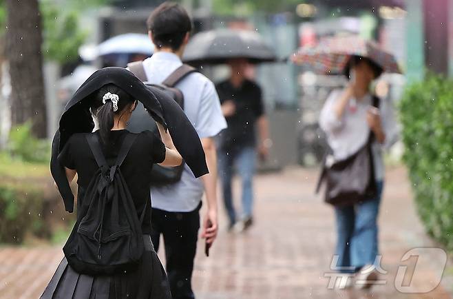 서대문역 인근에서 우산을 준비 못한 한 시민이 외투로 머리를 가리며 이동하고 있다. 2025.7.8/뉴스1 ⓒ News1 김진환 기자