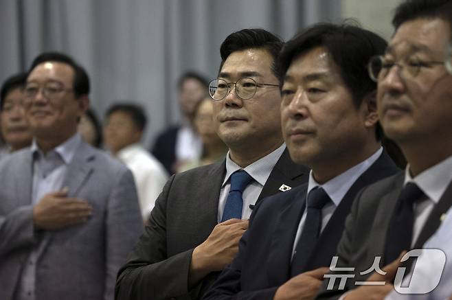 박찬대 더불어민주당 당대표 후보가 13일 울산시 남구 울산상공회의소 7층 대회의실에서 열린 게릴라 토크콘서트에 참석해 국기에 경례를 하고 있다. 2025.7.13/뉴스1 ⓒ News1 조민주 기자