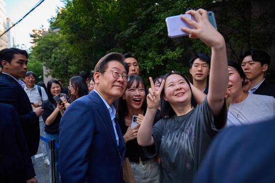 이재명 대통령이 지난 11일 저녁 서울 종로구의 한 고깃집에서 직원들과 퇴근길 외식을 하기 위해 이동하던 중 시민들과 기념촬영하고 있다. 사진 대통령실