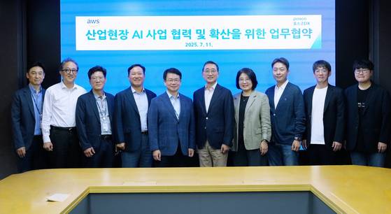 Posco DX CEO Shim Min-suk (fifth from left) and AWS Korea general manager Ham Kee-ho (sixth from left), along with other company officials, pose for a photo after signing a memorandum of understanding to collaborate on expanding AI adoption in industrial sites. [POSCO DX]