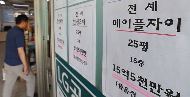 지난달 23일 서울 시내의 한 부동산에 붙은 전세 매물 안내문 앞으로 시민이 지나고 있다. 연합뉴스