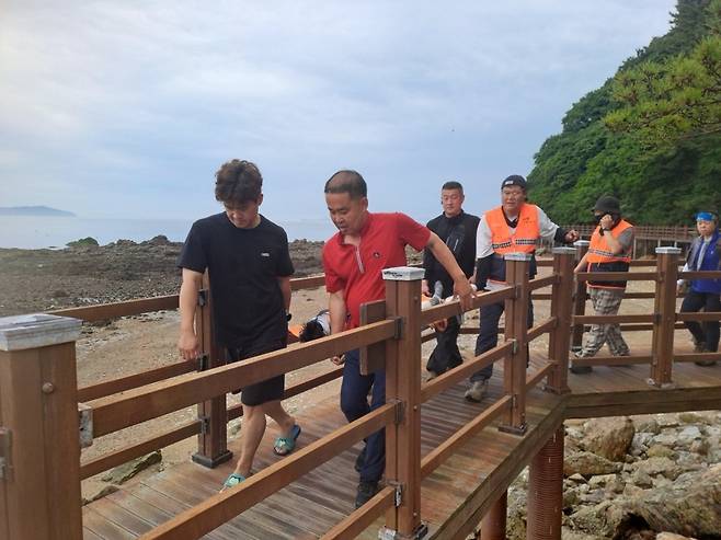 ▲ 13일 오후 인천 옹진군 승봉도에서 전담의용소방대원들이 60대 A씨를 구조하고 있다./사진제공=인천소방본부