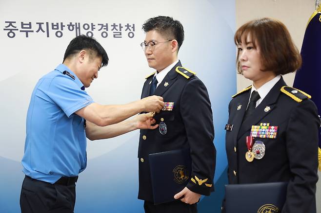 모범공무원 표장(메달)을 받는 중부해경청 신기택·김민경 경위. <중부해경청 제공>