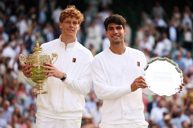 윔블던 테니스 대회 남자 단식에서 우승을 차지한 얀니크 신네르(왼쪽)와 준우승한 카를로스 알카라스가 나란히 트로피를 들고 기념촬영을 하고 있다. 사진=AFPBBNews