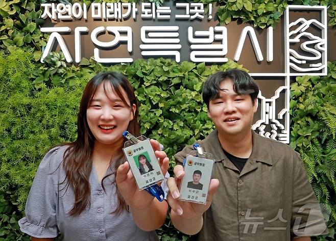 10여 년 전 학원 선생님과 제자로 만났던 충북 괴산군청 박은지 주무관(왼쪽)과 이수근 주무관이 재회한 뒤 공무원증을 들어 보이며 기념촬영을 하고 있다.2025.07.14.(괴산군 제공). ⓒ News1 이성기 기자