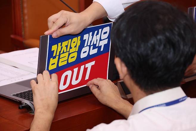 14일 서울 여의도 국회에서 열린 강선우 여성가족부 장관 후보자의 인사청문회에 앞서 국민의힘 의원실 관계자들이 소속 의원 노트북에 강 후보자를 규탄하는 피켓을 붙이고 있다. 2025.07.14. 뉴시스