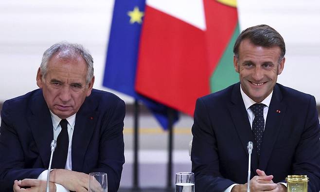 에마뉘엘 마크롱 프랑스 대통령(오른쪽)과 프랑스와 바이루 총리가 12일 프랑스 파리 엘리제궁에서 누벨칼레도니아 정치계 대표들과 만나, 누벨칼레도니에 대한 헌법상 ‘국가’ 지위 부여를 축하하고 있다. AP 연합뉴스