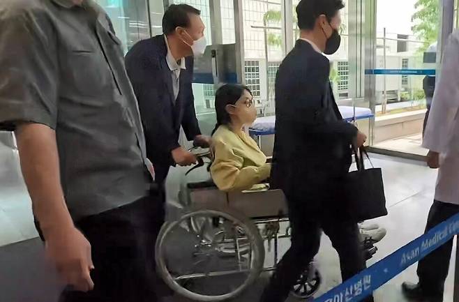 윤석열의 부인 김건희씨가 2025년 6월27일 서울 송파구 서울아산병원에서 윤석열이 미는 휠체어에 탄 채 퇴원하고 있다. 연합뉴스